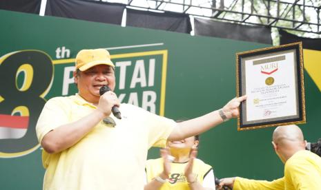 Ketua Umum DPP Partai Golkar Airlangga Hartarto memerlihatkan catatan rekor MURI dalam kegiatan jalan sehat menyambut HUT ke-58 Partai Golkar di Kompleks Gelora Bung Karno, Jakarta, Ahad (16/10/2022).