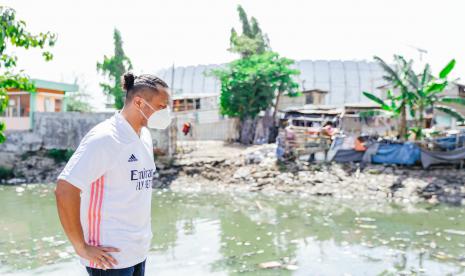 Ketua Umum DPP Partai Solidaritas Indonesia (PSI), Giring Ganesha Djumaryo berfoto di kampung kumuh dengan latar belakang Jakarta Internasional Stadium (JIS), Tanjung Priok, Jakarta Utara, Jumat (21/1/2022).