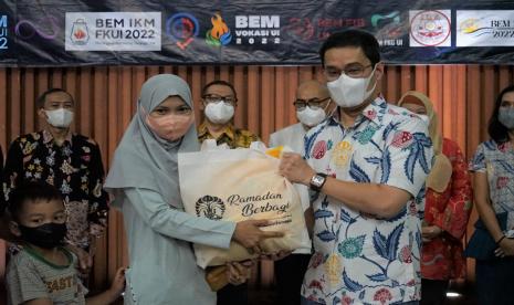 Ketua Umum Iluni UI Andre Rahadian (kanan) saat memberikan secara simbolis paket bantuan sembako di Balairung, Kampus UI Depok, Sabtu (23/4/2022).