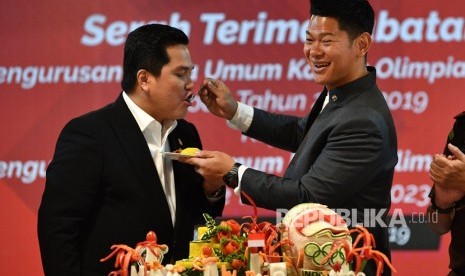 Ketua Umum Komite Olimpiade Indonesia (KOI) periode 2019-2023 Raja Sapta Oktohari (kanan) menyuapi Menteri BUMN yang juga Ketua Umum KOI periode 2015-2019 Erick Thohir saat serah terima jabatan di Kantor Pusat KOI, Jakarta, Senin (4/11/2019).