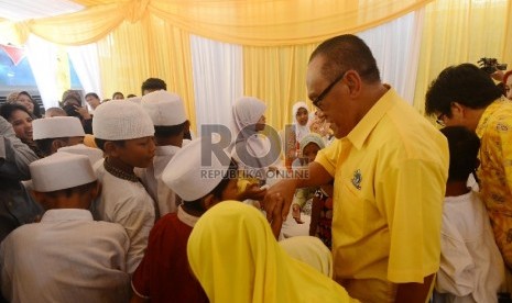 Ketua umum Parta Golongan Karya (Golkar) versi Munas Bali, Aburizal Bakrie menyalami anak yatim saat perayaan HUT Golkar yang ke-51 di Kampung Pulo, Jakarta Timur, Selasa (20/10).