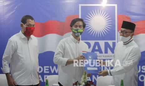 Ketua Umum Partai Amanat Nasional (PAN) Zulkifli Hasan (kanan) memberikan berkas dukungan dari Partai Amanat Nasional (PAN) pada Bakal Calon Wali Kota Solo, Gibran Rakabuming Raka (tengahi) dan Bakal Calon Wakil Wali Kota Solo, Teguh Prakosa (kiri), untuk maju pada Pilwalkot Solo di Komplek Widya Chandra, Jakarta, Rabu (12/8/2020). Kunjungan Gibran dan Teguh dalam rangka bersilaturahmi dan meminta dukungan PAN atas pencalonan mereka maju dalam Pilwalkot Solo Desember mendatang. 