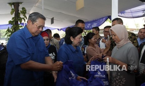 Ketua Umum Partai Demokrat Susilo Bambang Yudhoyono (kiri) didampingi Ibu Ani Yudhoyono memberikan paket sembako yang telah dibeli oleh warga saat acara Gerakan Pasar Murah Demokrat di Wisma Proklamasi, Jakarta, Kamis (7/6).