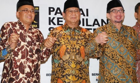 Ketua Umum Partai Gerindra Prabowo Subianto (tengah) bergandengan tangan dengan Presiden PKS Sohibul Iman (kiri) dan Ketua Majelis Syuro PKS Salim Segaf Aljufri (kanan) seusai melakukan pertemuan di DPP PKS, Jakarta, Senin (30/7).