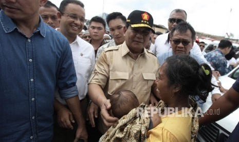 Ketua Umum Partai Gerindra Prabowo Subianto (tengah) bersama calon gubernur DKI Jakarta Anies Baswedan (kedua kiri) mendatangi wilayah Kampung Akuarium, Penjaringan, Jakarta Utara, Sabtu (7/1)