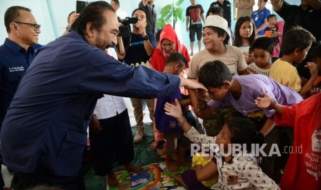 Ketua Umum Partai Nasdem Surya Paloh mengunjungi pengungsi korban banjir di Mamuju, Sulawesi Barat, Ahad (24/3).