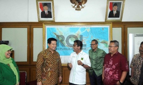 Ketua Umum Partai Persatuan Pembangunan (PPP) versi muktamar PPP Surabaya, Jawa Timur, Romahurmuziy (kanan) disambut oleh Ketua KPU Husni Kamil Manik (kiri) di Gedung KPU, Jakarta, Selasa (27/1). (Republika/Agung Supriyanto)