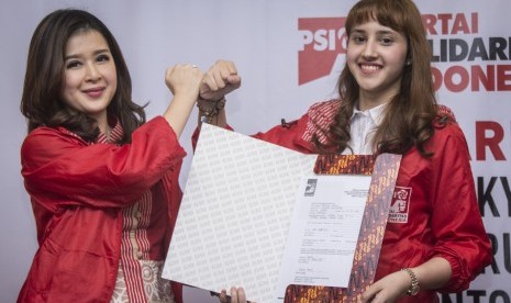 Ketua Umum Partai Solidaritas Indonesia (PSI) Grace Natalie (kiri) bersama Calon Legislatif (Caleg) PSI yang juga Ketua DPP PSI Bidang Eksternal Tsamara Amany (kanan) menunjukkan formulir pendaftaran Tsamara Amany sebagai Caleg PSI di Kantor DPP PSI, Tanah Abang, Jakarta, Kamis (26/10).