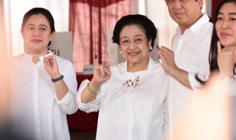 Ketua Umum PDI Perjuangan yang juga Presiden kelima RI Megawati Soekarnoputri (tengah) bersama putrinya Puan Maharani (kiri) dan putranya Muhammad Prananda Prabowo (kedua kanan) menunjukkan jarinya yang telah dicelup tinta seusai menggunakan hak pilihnya pada Pemilu 2019 di TPS 62, Kebagusan, Jakarta, Rabu (17/4/2019).