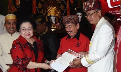 Ketua Umum PDIP Megawati Soekarnoputri (kiri) menyerahkan surat rekomendasi partai kepada pasangan Bacagub-Cawagub Lampung Herman Hasan Nusi (kedua kanan) dan Sutono (kanan) dalam acara penetapan bakal calon gubernur dan wakil gubernur yang diusung PDIP di Jakarta, Kamis (4/1).