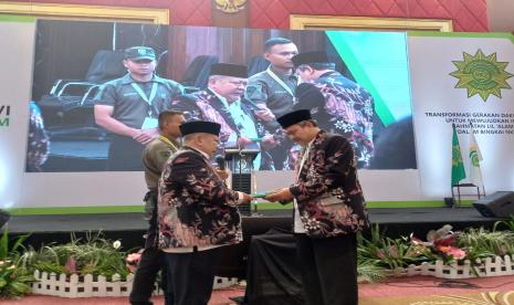 Ketua Umum Persis Masa Jihad 2015-2022 KH Aceng Zakaria menyerahkan buku secara simbolis kepada Ketua Umum Persis terpilih masa jihad 2022-2027 KH Jeje Zaenudin di Hotel Sutan Raja, Kabupaten Bandung, Senin (26/9/2022). 