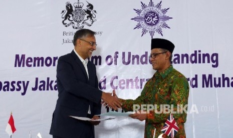 Ketua Umum Pimpinan Pusat Muhammadiyah Haedar Nasir (kanan) dan Duta Besar Inggris untuk Indonesia Moazzam Malik bertukar nota kesepahaman bersamai usai ditandatangani bersama, Senin (16/5) di Jakarta.  (Republika / Darmawan)