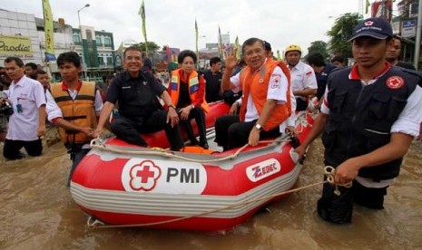  Ketua Umum PMI Jusuf Kalla didampingi pengurus PMI menggunakan perahu karet meninjau lokasi banjir di kawasan Kampung Melayu Besar, Jakarta, Rabu (16/1). 