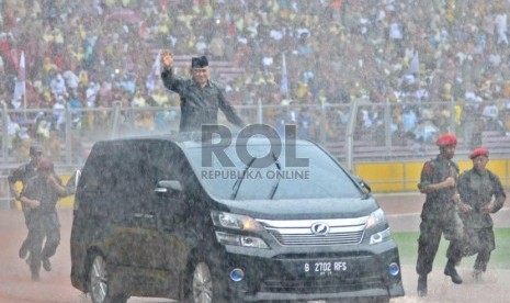  Ketua Umum PP Muhammadiyah Din Syamsuddin menyambut peserta di tengah derasnya hujan dalam acara Milad Seabad Muhammadiyah di Gelora Bung Karno (GBK), Jakarta, Ahad (18/11).  (Republika/Aditya Pradana Putra)