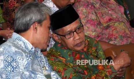 Ketua Umum PP Muhammadiyah Haedar Nashir (kanan) berbincang dengan Direktur Utama Bank Syariah Mandiri Agus Sudiarto usai menandatangani nota kesepakatan bersama di Jakarta, jumat (5/8). 