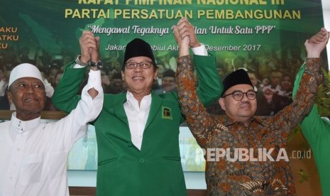 Ketua Umum PPP Djan Faridz (tengah) mengangkat tangan bersama dengan bakal calon gubernur Jawa Tengah Sudirman Said (kanan) dan KH Nur Iskandar SQ (kiri) dalam Rapimnas III PPP di Jakarta, Rabu (20/12).