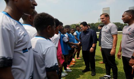 Ketua Umum PSSI Erick Thohir (ketiga kanan) didampingi Direktur Papua Football Academy Wofgang Pikal (kedua kanan) berbincang bersama siswa dari Papua Football Academy saat coaching clinic di Stadion Madya, Senayan, Jakarta, Jumat (8/9/2023).