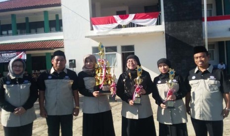 Ketua YBBI Dr Sutrisno Muslimin MSi (kedua dari kiri) menyerahkan piala unit sekolah terbersih kepada kepala SMP, SD dan KB/TK Bosowa Bina Insani.