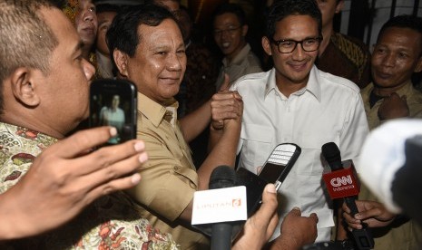 Ketum Partai Gerindra Prabowo Subianto (kedua kiri) bersama bakal calon gubernur DKI Jakarta Sandiaga Uno (kedua kanan) melakukan salam komando saat tiba di kediaman Prabowo Subianto, Jakarta, Kamis (22/9).