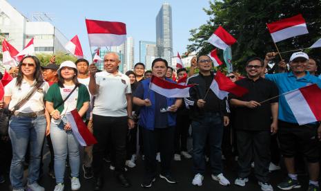 Ketum PSSI Erick Thohir (tengah) dan Wali Kota Surabaya Eri Cahyadi (ketiga kanan) mengibarkan bendera saat Trophy Experience FIFA U-17 World Cup di Jalan Gubernur Suryo, Surabaya, Jawa Timur, Ahad (29/10/2023).