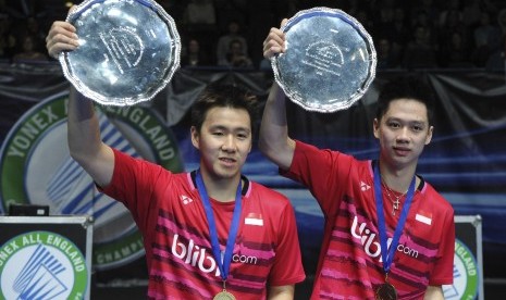 Kevin Sanjaya Sukamuljo (kanan) and Marcus Fernaldi Gideon mengangkat trofi kemenangan mereka di All England 2017, (12/3).