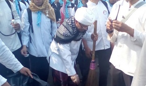  KH Abdullah Gymnastiar atau Aa Gym memunguti sampah saat aksi damai 'Bela Islam Jilid II'.