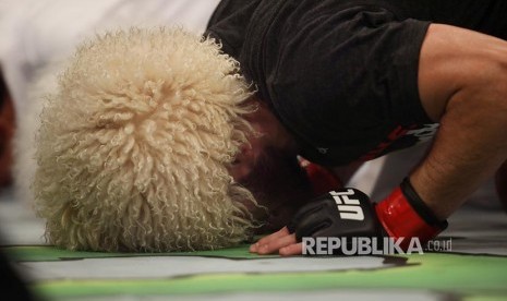 Khabib Nurmagomedov sujud syukur setelah mengalahkan Dustin Poirier pada laga perebutan gelar Kelas Ringan UFC Lightweight di Abu Dhabi, Uni Emirat Arab, Ahad (8/9) dini hari.