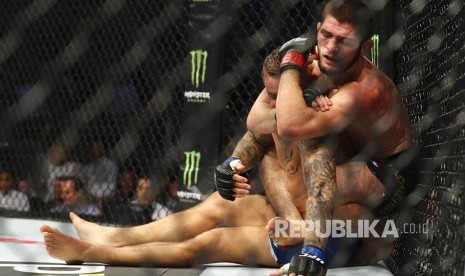 Khabib Nurmagomedov mengunci Dustin Poirier pada laga perebutan gelar Kelas Ringan UFC Lightweight di Abu Dhabi, Uni Emirat Arab, Ahad (8/9) dini hari.