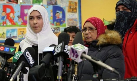 Khawlah Noman (kiri) berbicara kepada wartawan dengan didampingi ibunya di Pauline Johnson Junior Public School, Toronto, Kanada. Noman mengaku menjadi korban pengguntingan jilbab. 