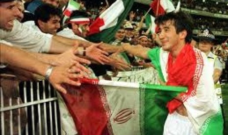 Khodadad Azizi, 'sang pahlawan', merayakan kemenangan atas Australia di playoff Piala Dunia 1998 dengan para suporter Iran.