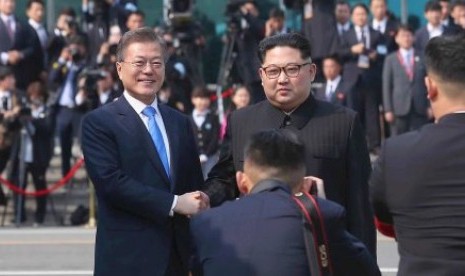  Kim Jong-un (kanan) berjabat tangan dengan Presiden Moon Jae-in. 