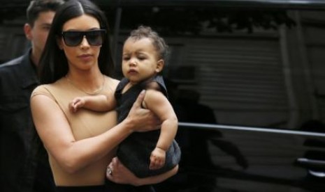 Kim Kardashian menggendong putrinya dengan Kanye West, North.