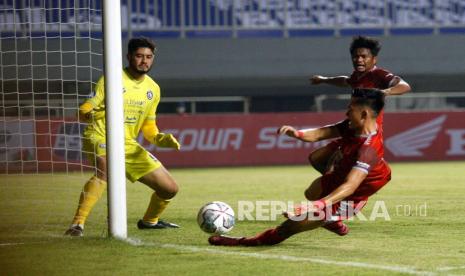 Kiper Arema FC Adilson Maringa (kiri) mencoba menghalau tendangan pesepakbola PSM Makassar Sutanto Tan (kanan) dalam lanjutan laga Liga 1 di Stadion Pakansari, Kabupaten Bogor, Jawa Barat, Ahad (5/9/2021).