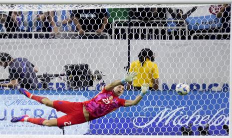 Kiper Argentina Emiliano Martinez menghentikan tendangan penalti Angel Mena dari Ekuador selama adu penalti pada pertandingan perempat final Copa America di Stadion NRG, Houston, JUmat (5/7/2024) pagi WIB.