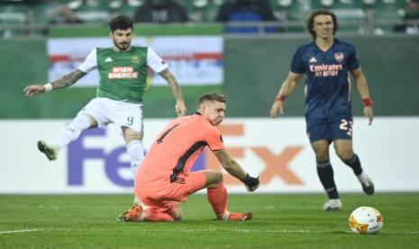 Kiper Arsenal Bernd Leno (tengah) membuat blunder sehingga gawangnya dibobol Taxiarchis Fountas dari Rapid Vienna di Liga Europa. Beruntung Arsenal bisa menang 2-1.