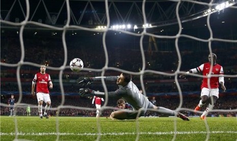 Kiper Arsenal, Lukasz Fabianski (tengah), gagal menghalau serangan pemain Bayern Muenchen, Thomas Muller, sehingga tercipta gol dalam leg pertama babak 16 besar Liga Champions di Stadion Emirates, London, Rabu (19/2). 