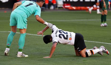 Kiper Athletic Bilbao Unai Simon (kiri) membantu penggawa Valencia Maxi Gomez untuk bangun ketika kedua tim bentrok di Stadion Mestalla, Kamis (2/7) dini hari WIB.