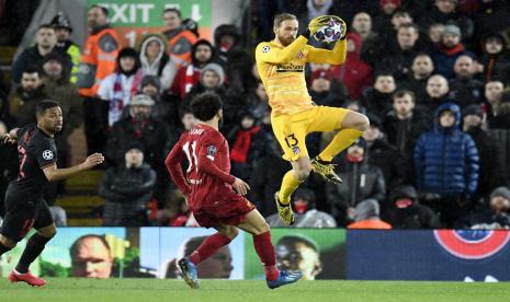 Kiper Atletico Madrid, Jan Oblak (kanan) menangkap bola di depan striker Liverpool, Mohamed Salah, pada laga Liga Champions, di Anfield, Kamis (12/3) dini hari WIB.