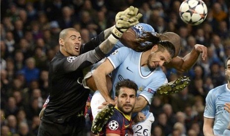 Kiper Barcelona, Victor Valdes, menonjok bola dalam duel udara saat menghadapi Manchester City di leg pertama babak 16 besar Liga Champions di Stadion Etihad, Manchester, Selasa (18/2). 