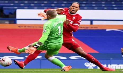 Kiper Everton (baju kuning) menghantam bek Liverpool Virgil van Dijk saat kedua tim berlaga pada lanjutan Liga Primer Inggris 2020/2021 di Goodison Park, Sabtu (17/10).