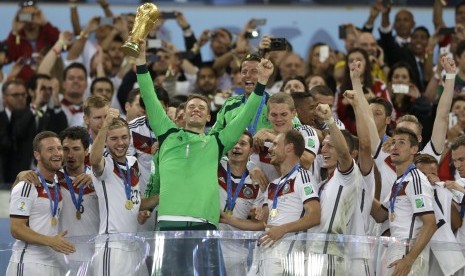 Kiper Jerman Manuel Neuer memegang trofi Piala Dunia setelah mengalahkan Argentina 1-0 pada laga final