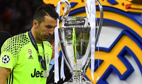 Kiper Juventus, Gianluigi Buffon berjalan di depan trofi Liga Champions seusai timnya kalah 1-4 dari Real Madrid pada laga final di Stadion Millennium, Cardiff, Ahad (4/6) dini hari WIB.