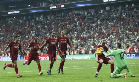 Kiper Liverpool Adrian merayakan kemenangan timnya bersama rekan-rekannya usai menggagalkan tendangan penalti pemain Chelsea Tammy Abraham di Piala Super Eropa, Kamis (15/8).