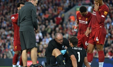 Kiper Liverpool, Alisson Becker (tiga kanan), mendapat penanganan medis saat menghadapi Norwich City di laga pembuka Liga Primer Inggris di Stadion Anfield, Liverpool, Jumat (9/8) malam waktu setempat.