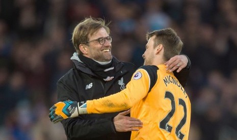 Kiper Liverpool, Simon Mignolet berpelukan dengan pelatih Juergen Klopp seusai mengalahkan Burnley pada Ahad (12/3).