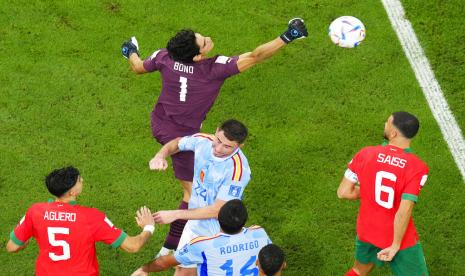  Kiper Maroko Yassine Bounou (atas) membersihkan bola selama pertandingan sepak bola babak 16 besar Piala Dunia antara Maroko dan Spanyol, di Stadion Education City di Al Rayyan, Qatar, Selasa, 6 Desember 2022. 