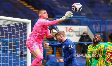 Kiper Sam Johnstone (kiri) menghalau bola dari jangkauan Timo Werner (kanan)  pada laga antara  Chelsea FC melawan West Bromwich Albion di London, Inggris, Sabtu (3/4)