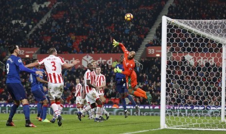 Kiper Stoke City, Lee Grant terbang untuk menghalau tendangan bebas striker Manchester United, Wayne Rooney yang akhirnya berbuah gol. Laga di stadion Bet365 itu berakhir imbang 1-1.