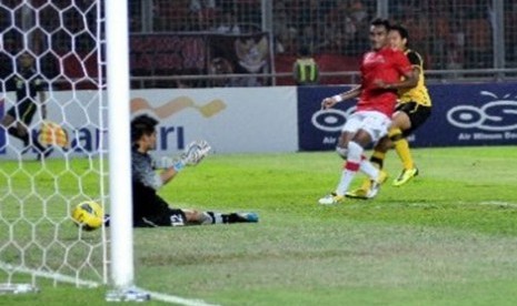 Kiper timnas Indonesia Andritany Ardhiyasa (kiri) tak kuasa menahan laju bola tendangan pesepakbola Malaysia Ibrahim Syahrul Azwari (kanan) yang berbuah gol saat pertandingan lanjutan babak kualifikasi Grup A SEA Games XXVI Indonesia di Stadion Utama Gelor