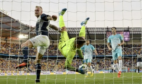 Kiper Timnas Slovenia, Vid Belec (tengah), melakukan penyelamatan dari serangan pemain Swedia, John Guidetti (kiri), dalam laga internasional di Malmo, Swedia, pada 30 Mei 2016. 